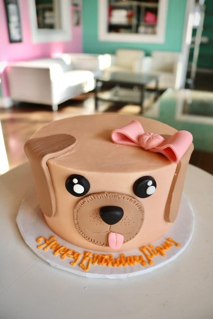 Pup face celebration cake with pink bow, perfect for pet birthdays and special occasions.
