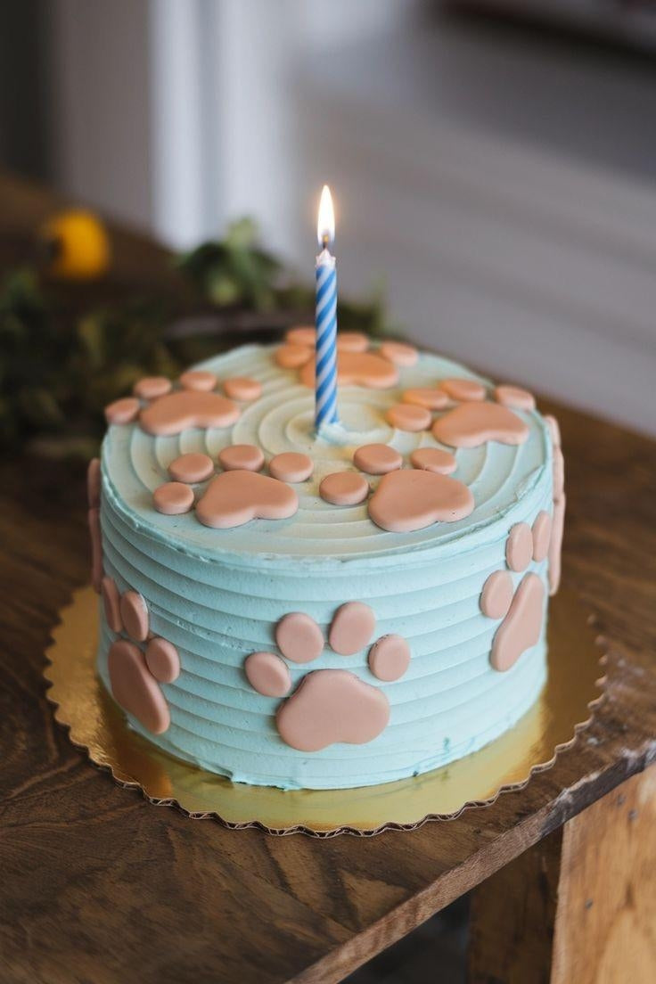 Blue Pawty Cake with peach paw prints and a birthday candle, perfect for celebrating your pet's special day.