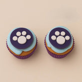Two Oreo Paw Print Pupcakes with blue and purple icing, perfect for dog-lover celebrations, now available for delivery across India.